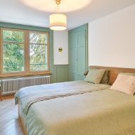 Bedroom with wooden floor and light-green accenting features