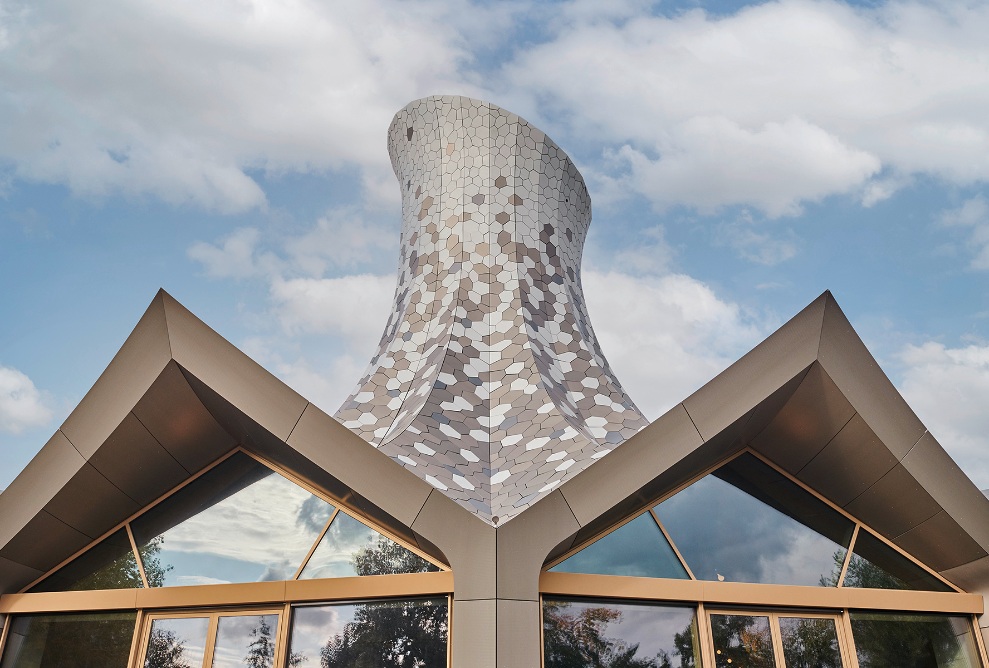 Des écailles métalliques de forme irrégulière recouvrent le toit autoportant, qui est conçu comme une structure pliante.